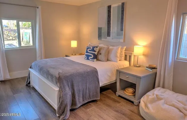 a bedroom with a bed and a tv with wooden floor