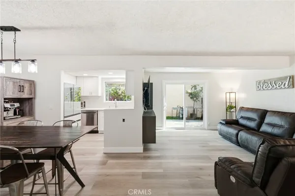 a living room with furniture a dining table and chairs with wooden floor