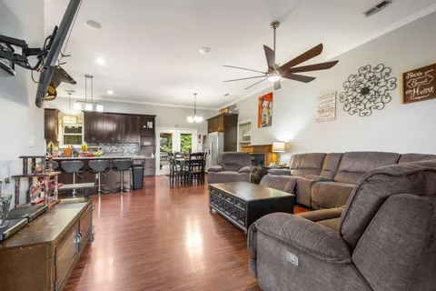 a living room with furniture kitchen view and a chandelier
