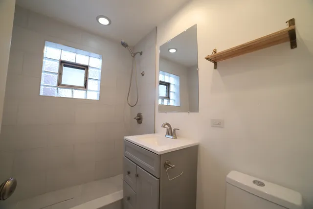 a bathroom with a sink mirror vanity and toilet