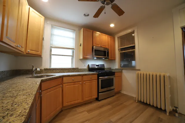 a kitchen with stainless steel appliances granite countertop a sink and microwave