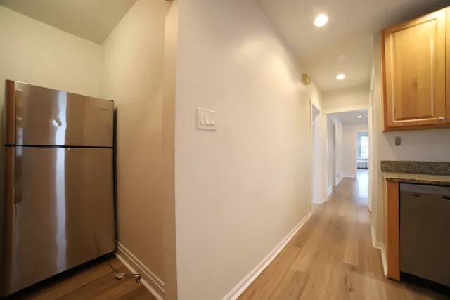 a view of a kitchen with a refrigerator and a stove top oven