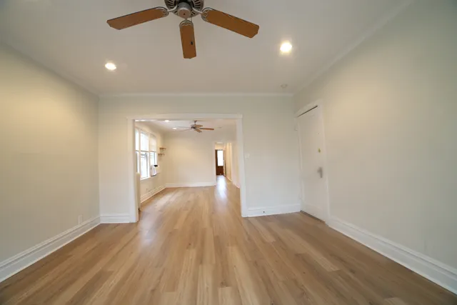a view of empty room with wooden floor