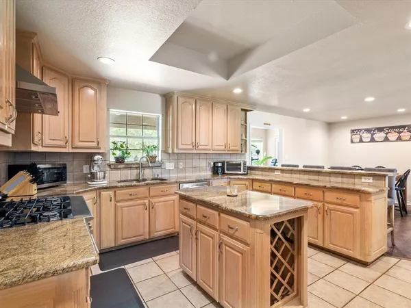 a kitchen with stainless steel appliances granite countertop a sink stove and cabinets