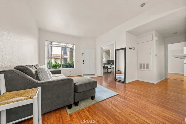 a living room with furniture and a wooden floor