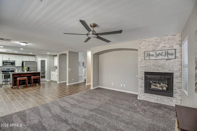 a living room with furniture a fireplace and kitchen view