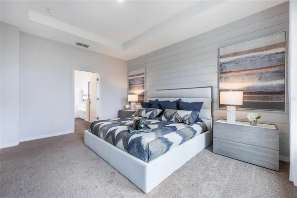 a bedroom with a bed a window and a painting on the wall
