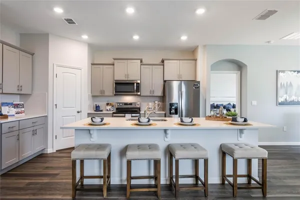 a kitchen with refrigerator a sink and chairs