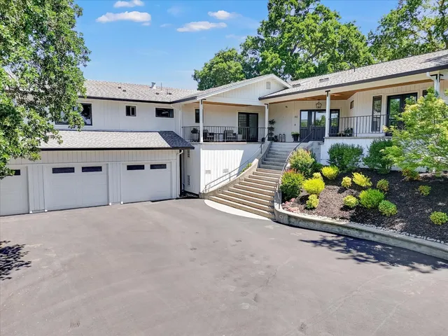 front view of a house with a yard and potted plants