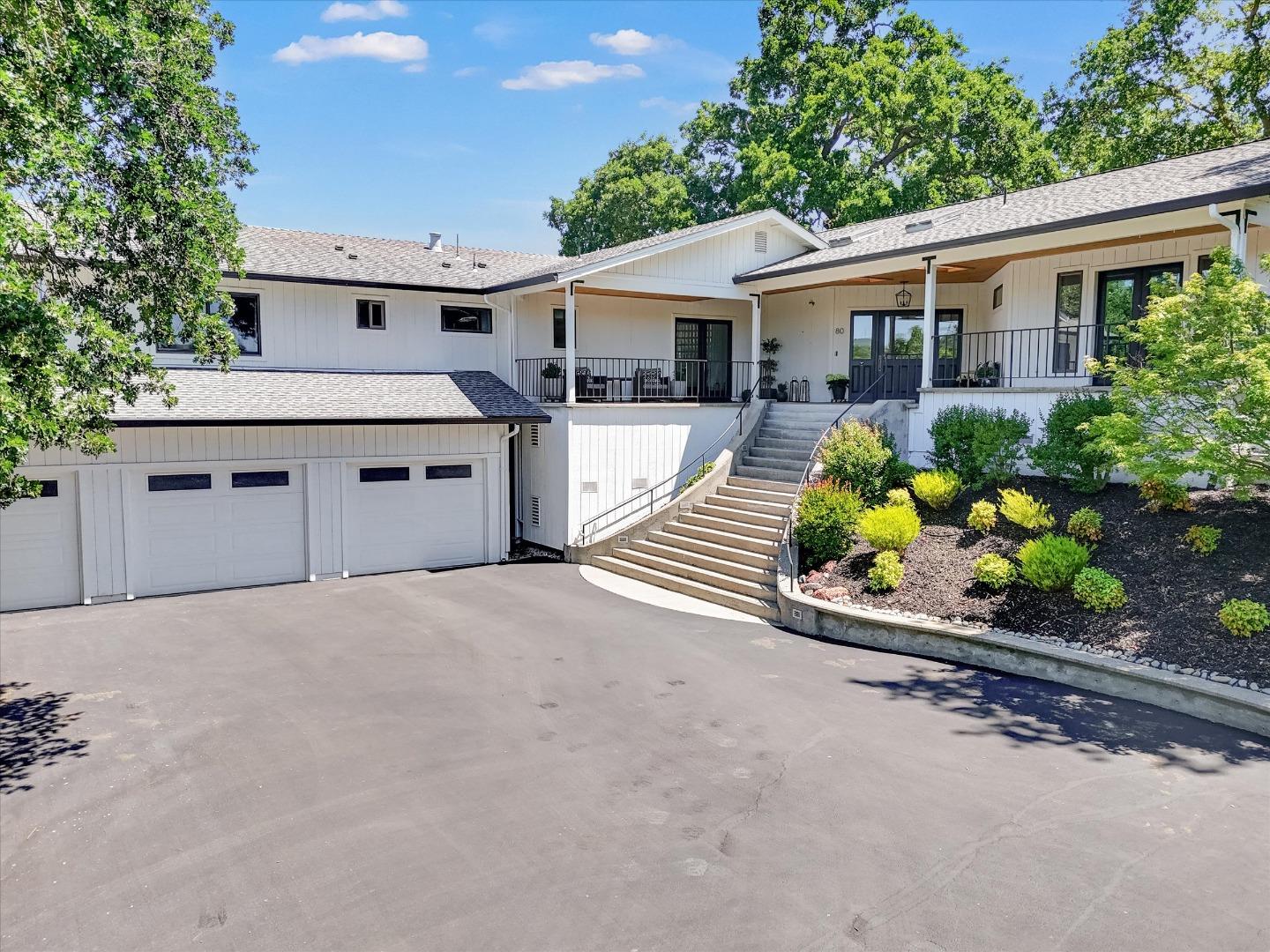 front view of a house with a yard and potted plants