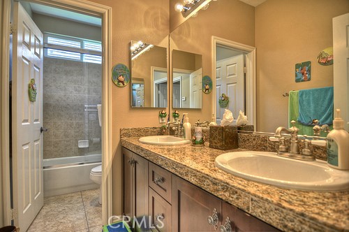 10 Prescott Aliso Viejo, CA 92656 - Photo 23 of 29 a bathroom with a granite countertop sink a mirror and a shower