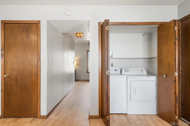 a living room with couches and a dining table with wooden floor