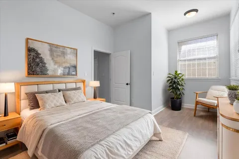 a bedroom with a large bed and a potted plant