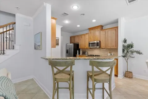 a kitchen with stainless steel appliances granite countertop a stove a sink a refrigerator and a refrigerator