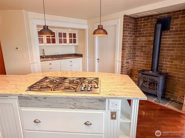 a kitchen with stainless steel appliances granite countertop a sink a stove and white cabinets