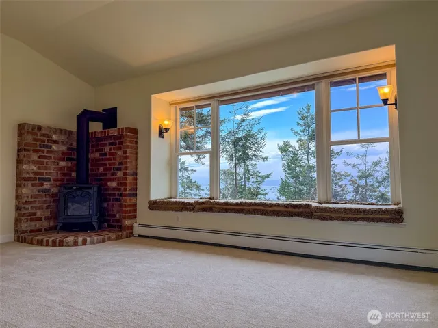 a view of an empty room with a fireplace and a window