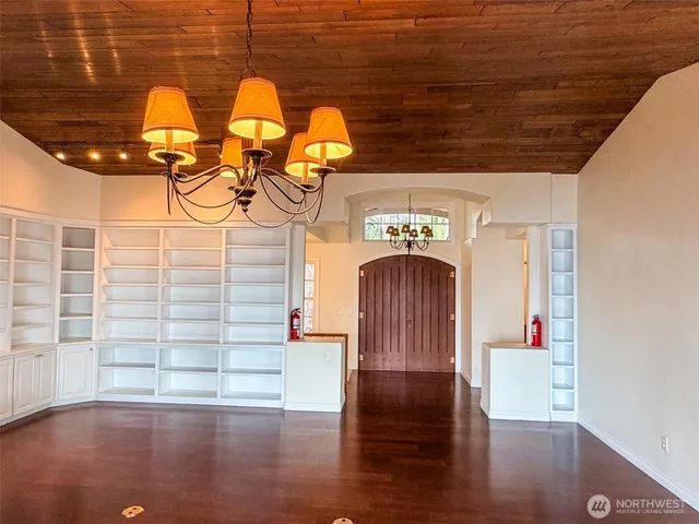 a view of empty room with wooden floor and fireplace