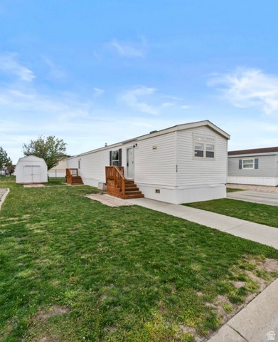 2491 Highway 89, Unit 608 Pleasant View, UT 84404 - Photo 1 of 1 View of front of home with a front lawn, a storage unit, and entry steps