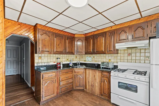 a kitchen with stainless steel appliances granite countertop a stove a sink dishwasher and a refrigerator