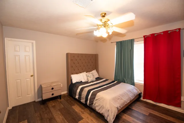 a bedroom with a bed and wooden floor