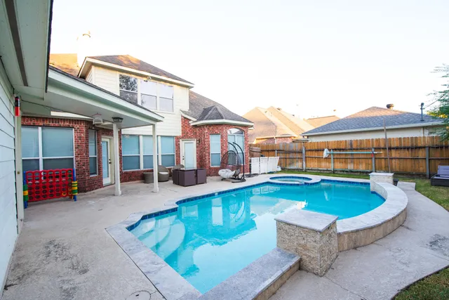 a view of a house with swimming pool and sitting area
