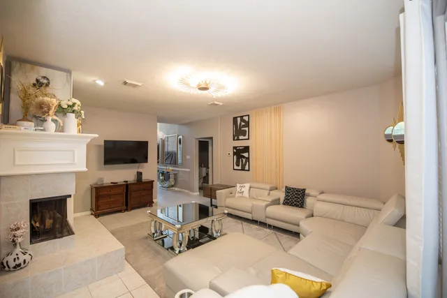 a living room with furniture a flat screen tv and a fireplace