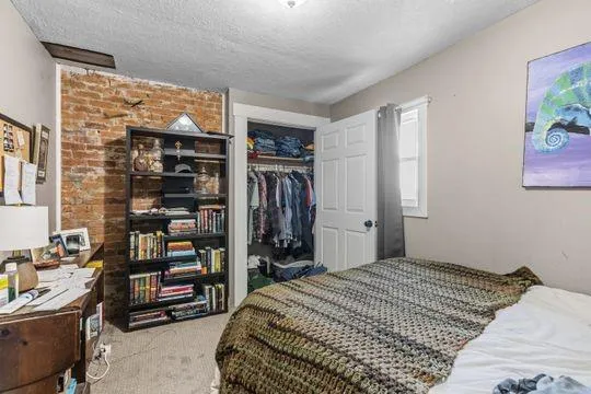 a bedroom with a bed and a book shelf