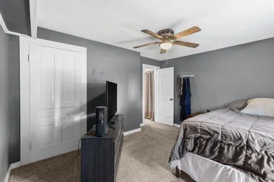 a bedroom with a bed and ceiling fan