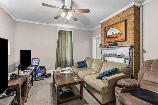 a living room with furniture a flat screen tv and a window
