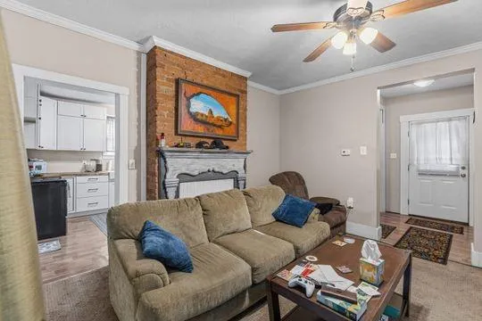 a living room with furniture a flat screen tv and kitchen view