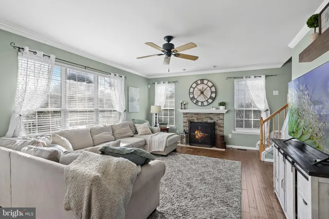 a living room with furniture a fireplace and a large window