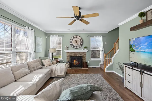 a living room with furniture a fireplace and a large window