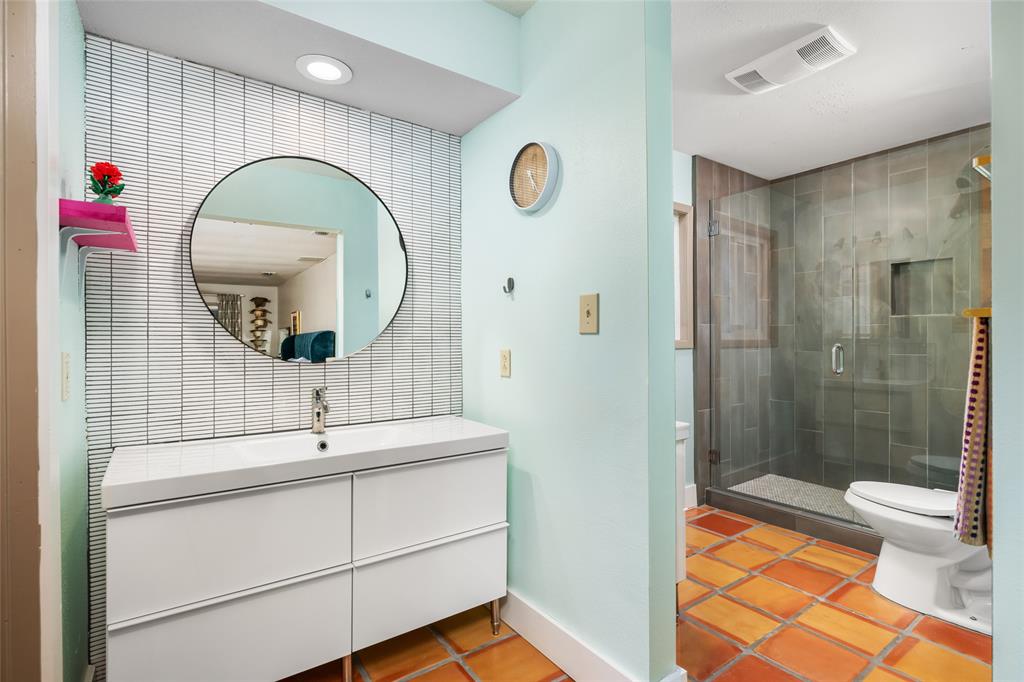 2210 Red Fox Road Austin, TX 78734 - Photo 28 of 40 A vibrant bathroom features a sleek vanity, an overhead shower, and rich, terracotta-hued tile flooring.