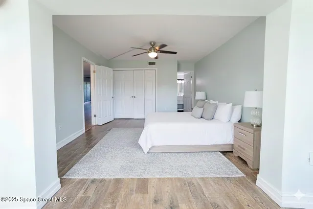 a spacious bedroom with a bed and a ceiling fan