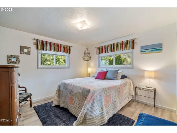 a bedroom with a bed wall painting and a window