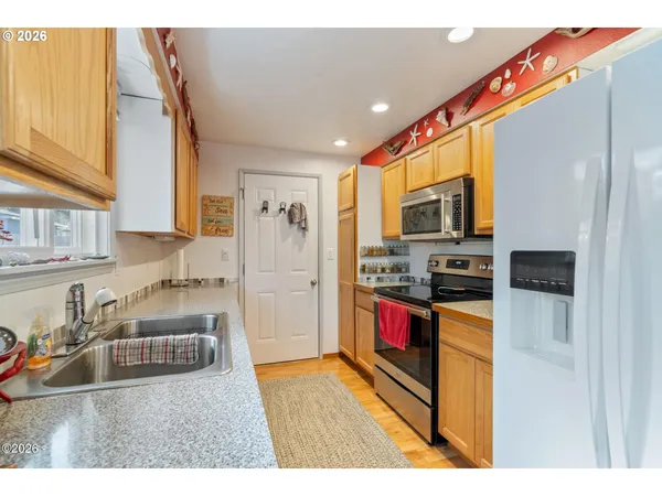 a kitchen with stainless steel appliances granite countertop a refrigerator and a sink