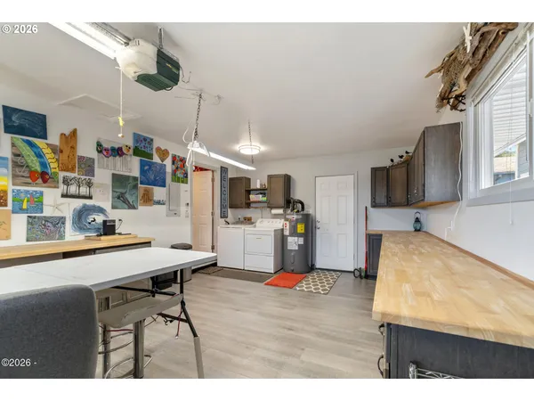 a room with stainless steel appliances kitchen island granite countertop furniture and a wooden floor