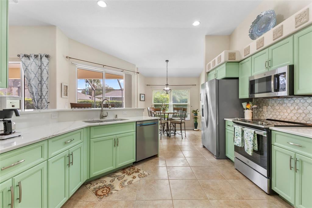5823 McKinley Road Venice, FL 34293 - Photo 11 of 44 a kitchen with stainless steel appliances granite countertop a sink stove and refrigerator