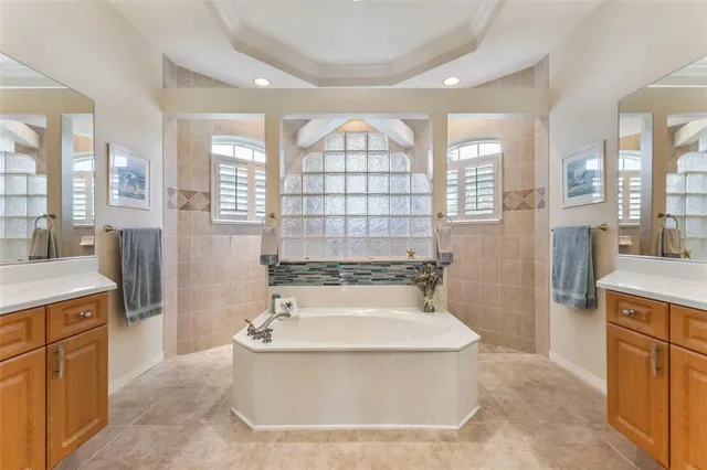 a bathroom with a tub a sink a mirror and a shower