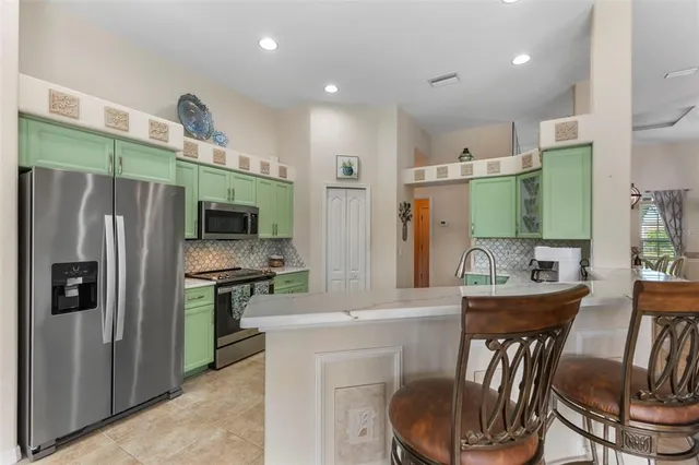 a kitchen with a table chairs refrigerator and microwave