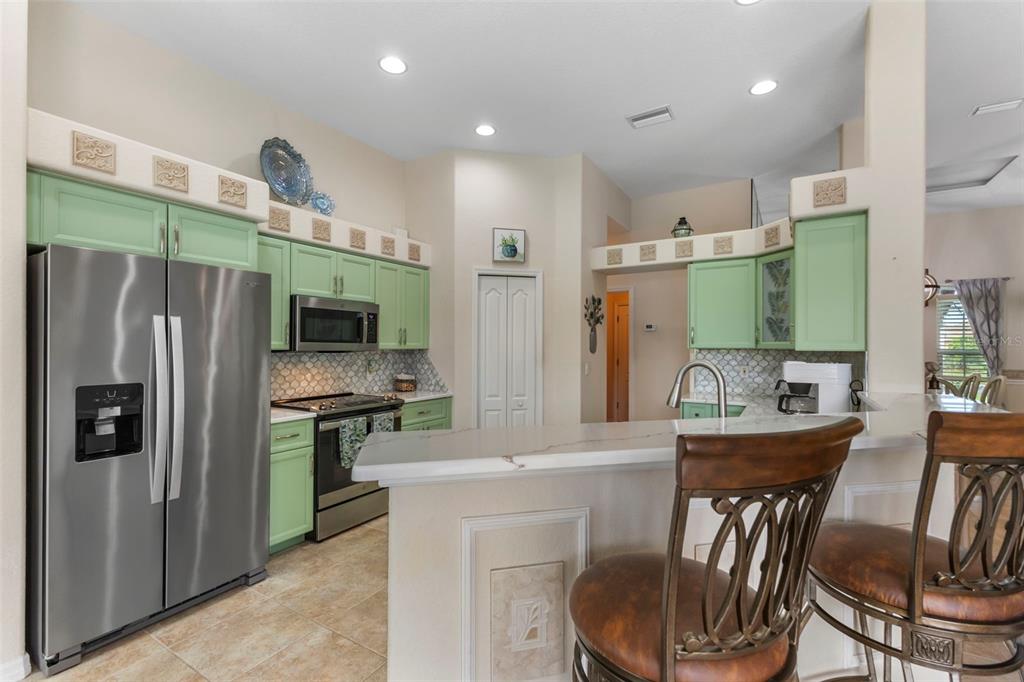 5823 McKinley Road Venice, FL 34293 - Photo 30 of 44 a kitchen with a table chairs refrigerator and microwave