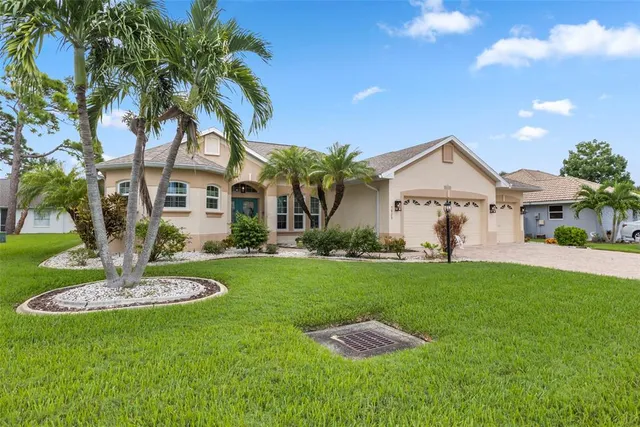 a front view of a house with a yard and palm trees