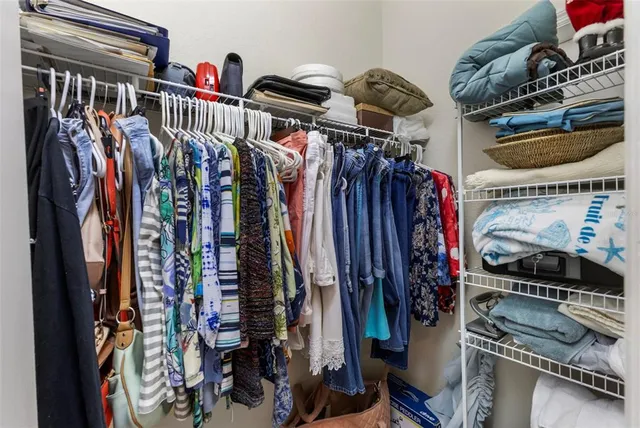 a view of walk in closet with clothes and shoes