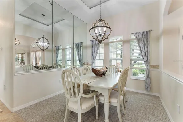 a view of a dining room with furniture a chandelier and wooden floor