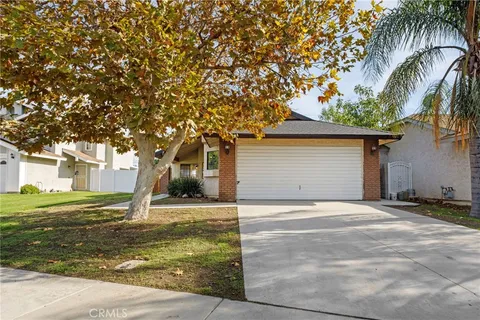 a front view of a house with a yard garage and trees