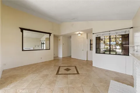 a view of an empty room with window and mirror