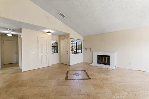 a view of an empty room with window and cabinet