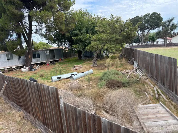 a view of a backyard with wooden fence