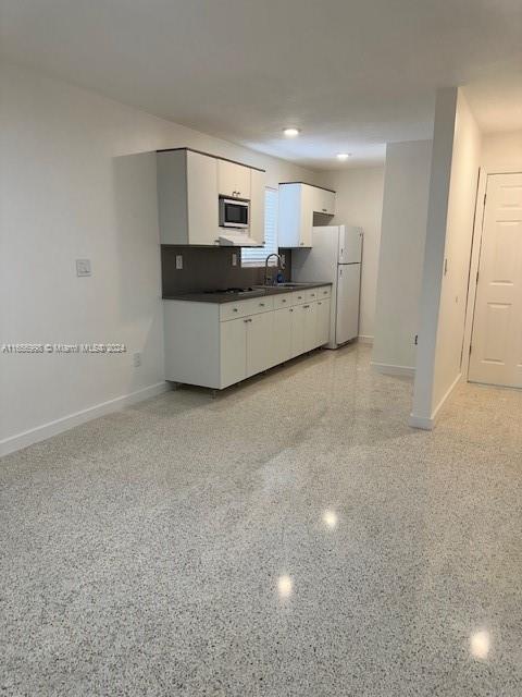 3677 Southwest 14th Street Miami, FL 33145 - Photo 4 of 12 a large white kitchen with kitchen island a sink stainless steel appliances and cabinets