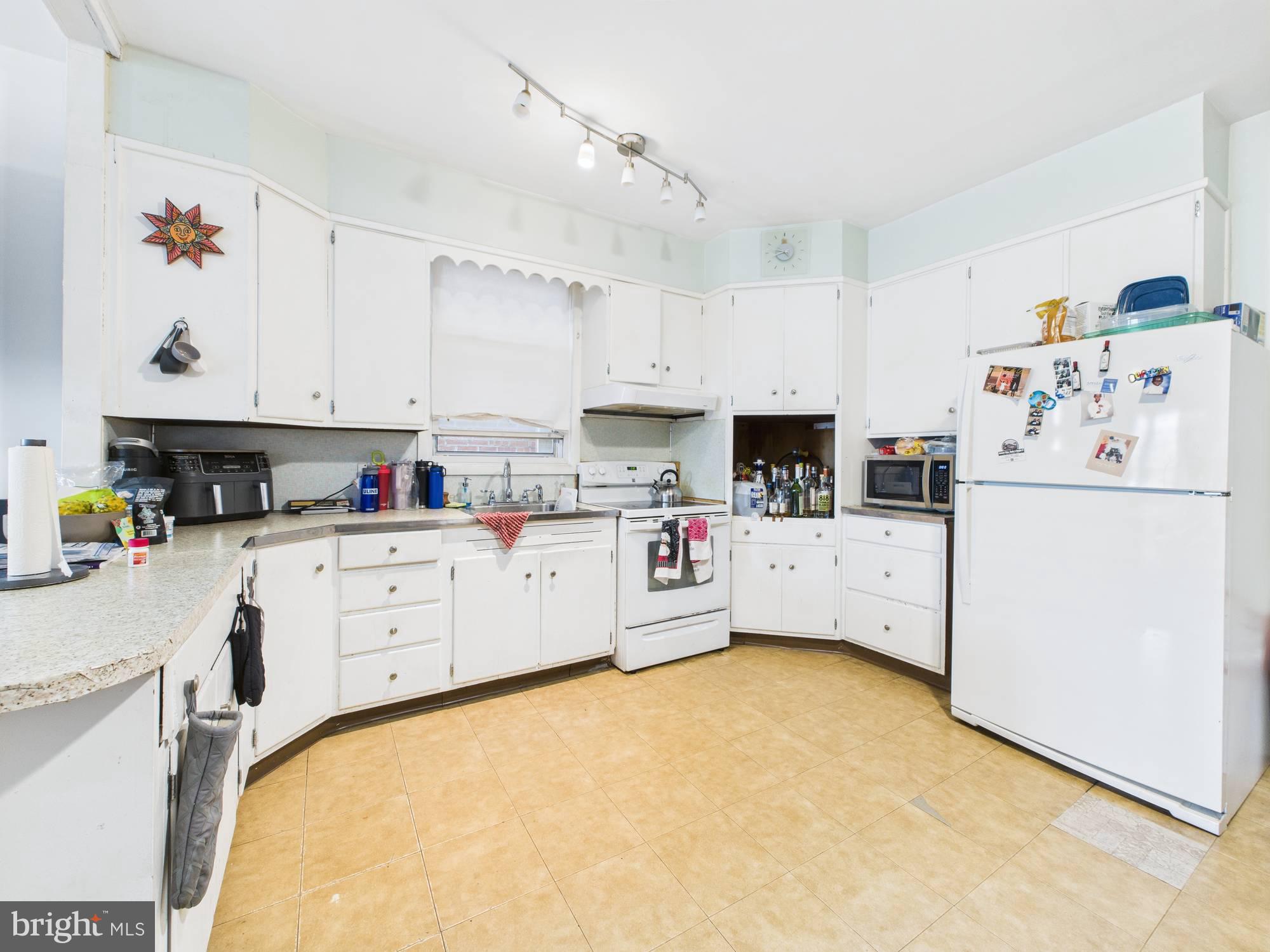 4073 West Ford Road Philadelphia, PA 19131 - Photo 14 of 50 a kitchen with cabinets and white appliances